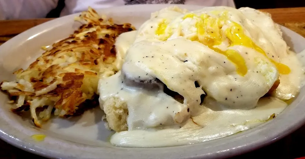 5 Sausage Bisquits Eggs Topped with Gravy and a Side of Hash Browns